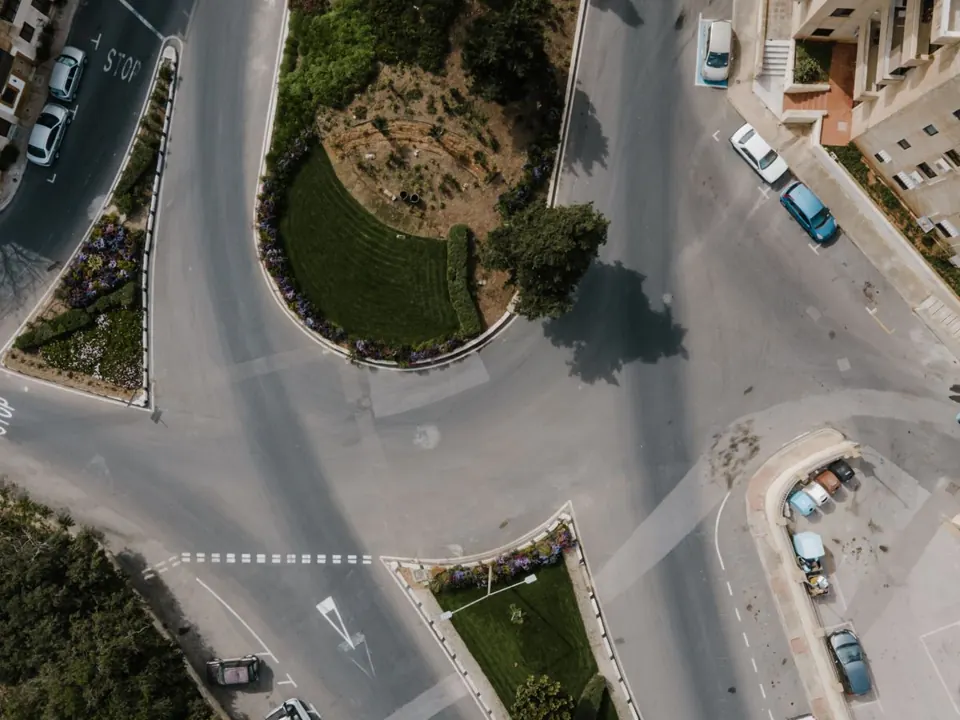Passenger vehicles travelling through a road junction in Kalkara, Malta