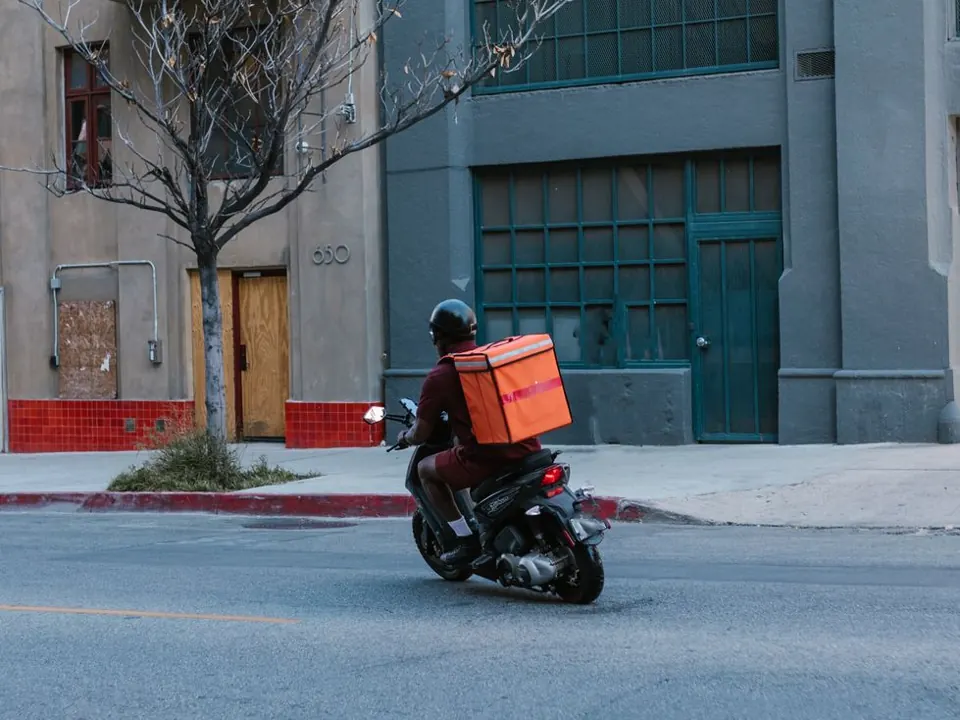 Helmeted rider on a motor scooter on an urban street
